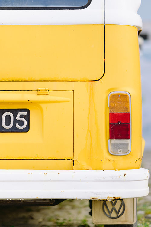 Old Volkswagen yellow camper van after rain in Paco de Arcos, Portugal