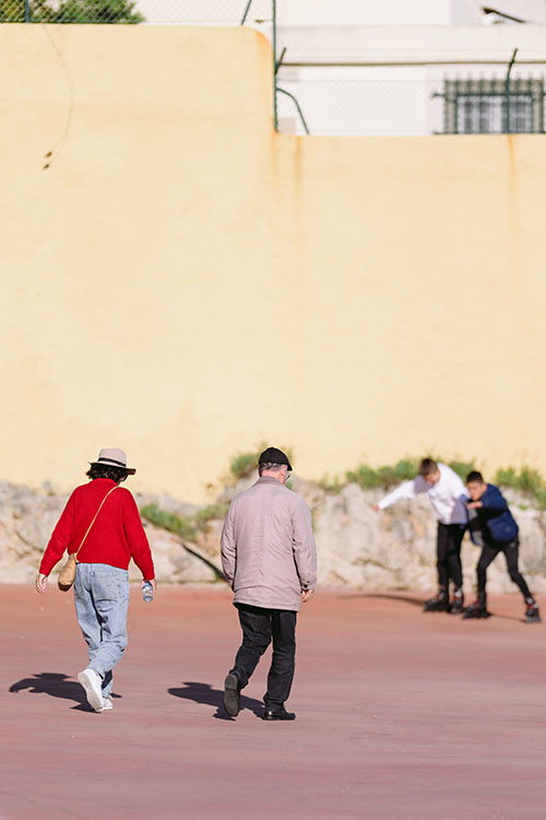 Old couple walking towards youngsters on rollerblades in Oeiras, Portugal